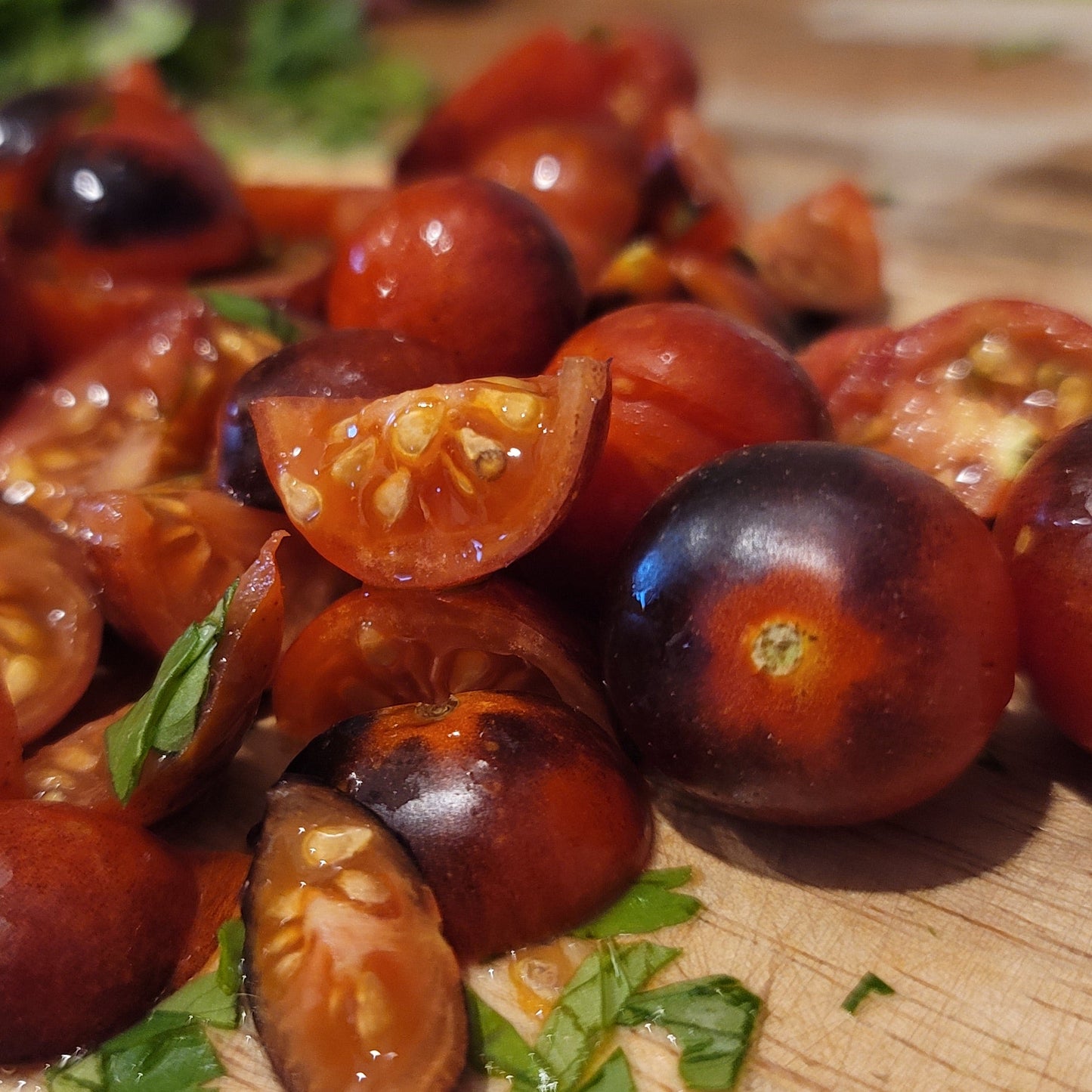 whole and quartered cherry tomatoes on bamboo cutting board